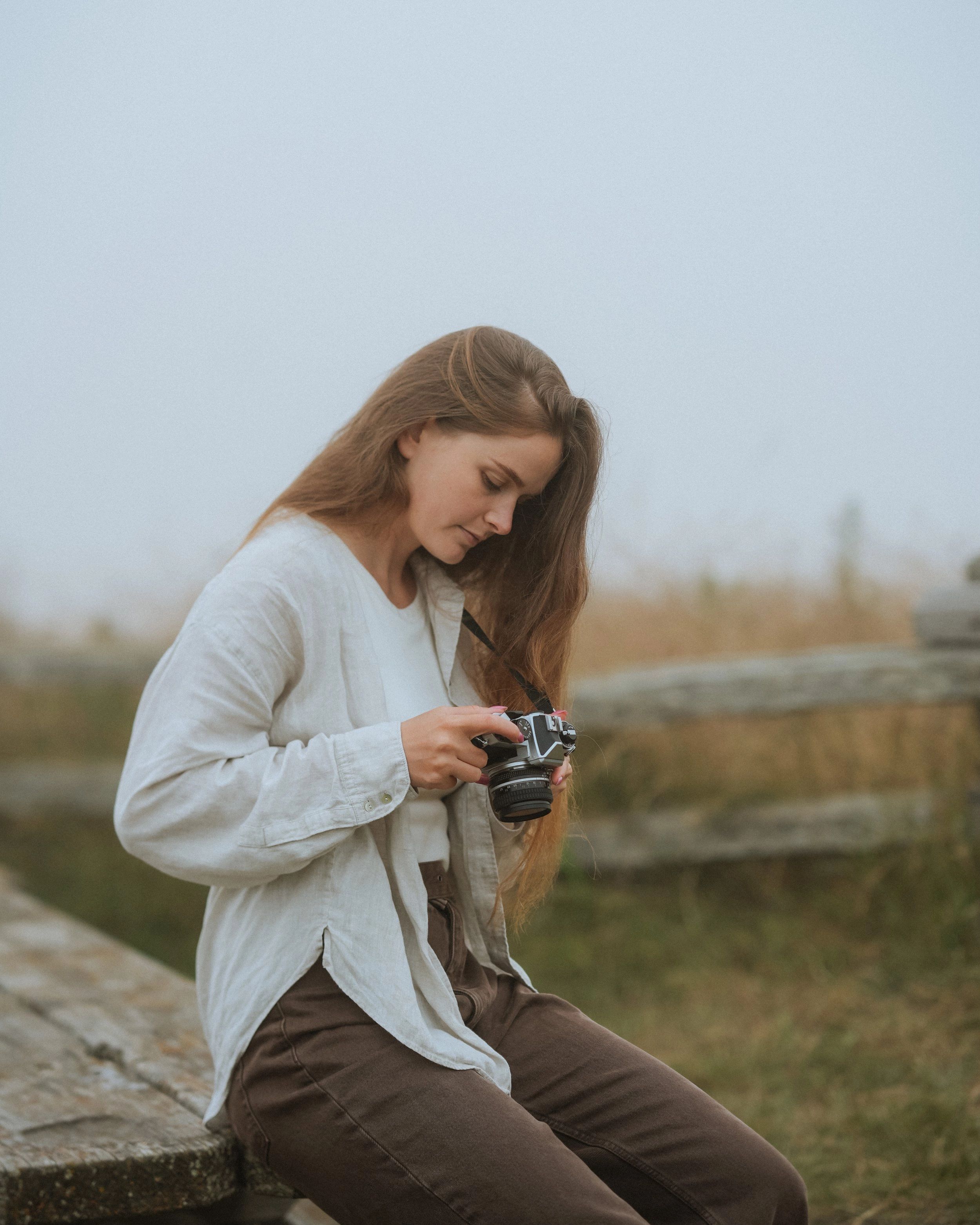 Kate from Pacifica Studio holding a camera outdoors